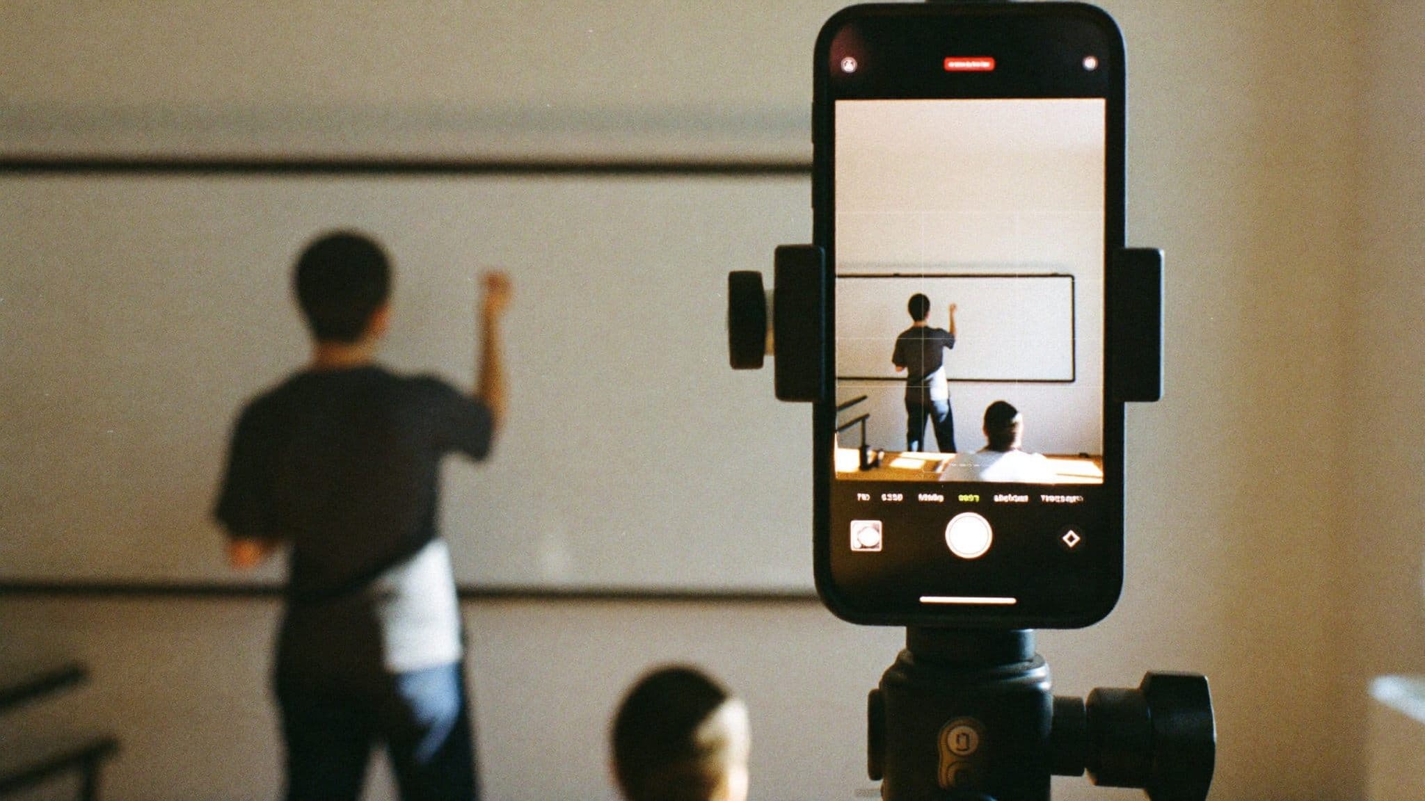 A phone on a tripod recording a talk
